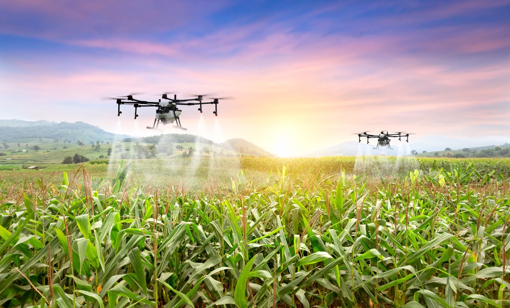 Drones spraying fertilizer on crops, part of the C Eden Series smart farming solutions for terrain scanning and research analysis.